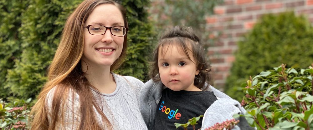 Leann holds her young daughter Rosalie, who is wearing a Google t-shirt