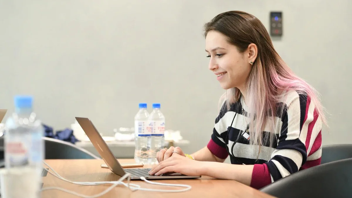 Elena sitting while working at a laptop.