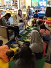 Photo of Laura talking with young students in a classroom at the California School for the Blind