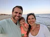 Brian on the beach with his wife and daughter.