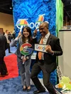 Two people posing with props at a career fair booth.