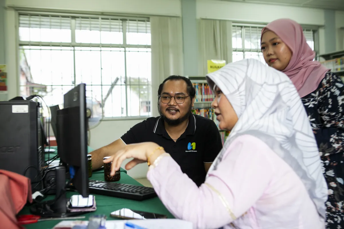 Three people looking at a computer screen