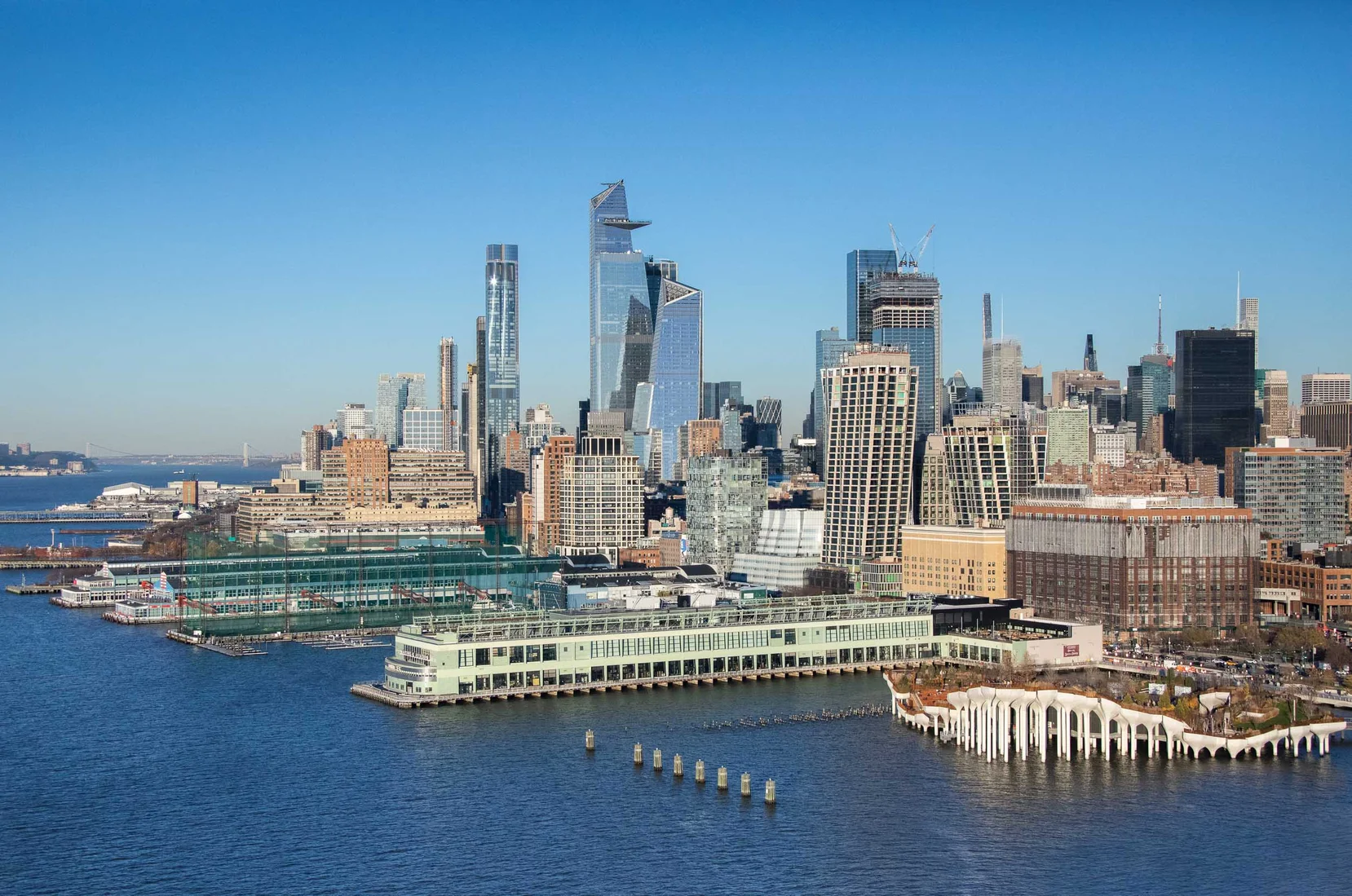 Waterfront shot against downtown Manhattan skyline of Google’s new Pier 57 office in New York, with a public food hall and community spaces opening in 2022.