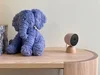 Nest cam next to a cuddly purple elephant toy