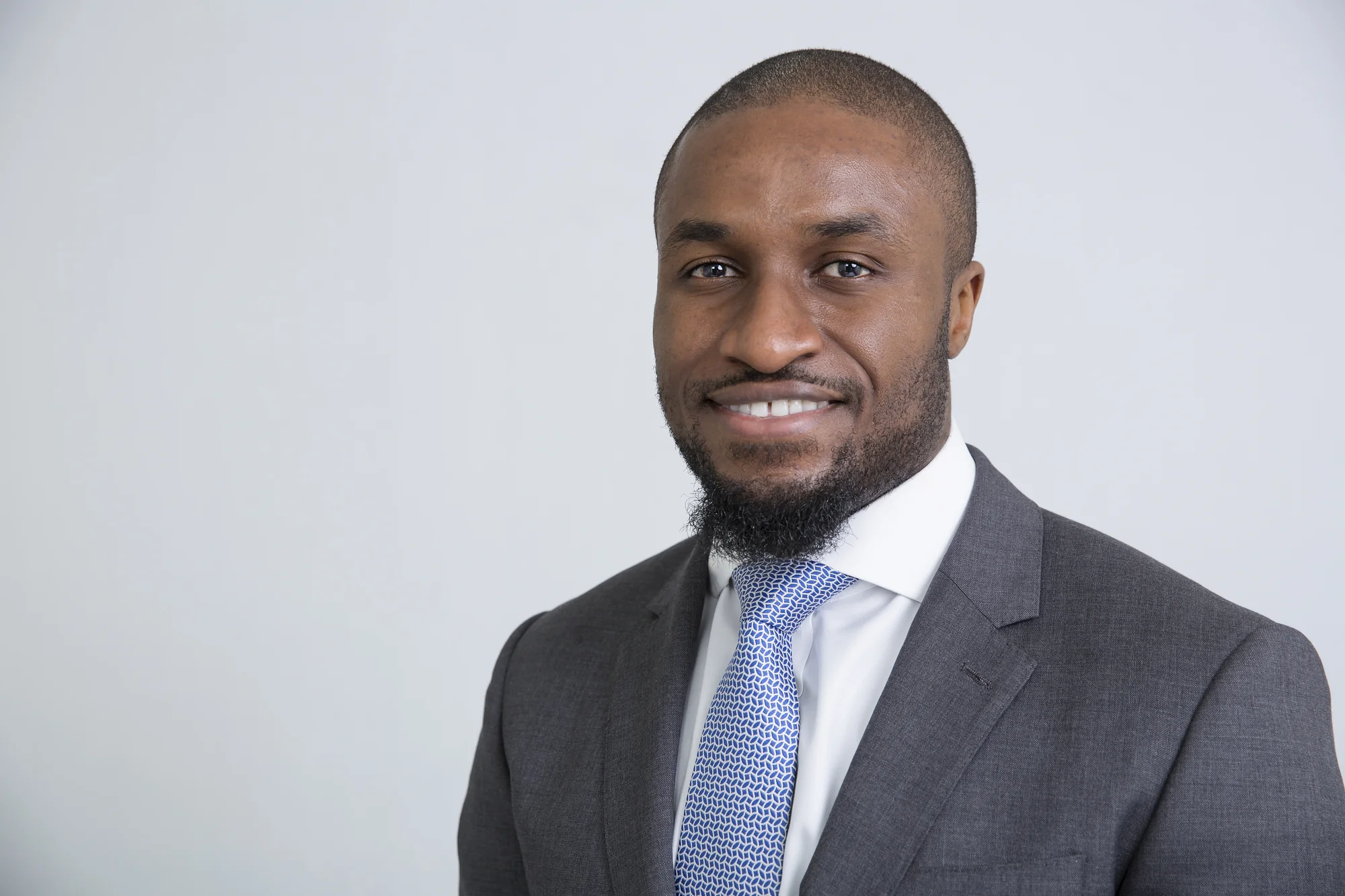 Headshot of Nnamdi Emelifeonwu wearing a suit, looking into the camera and smiling.