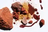 Image of ochre in various forms: as a rock, as powder and as liquid. Image is in hues of red, yellow and brown.
