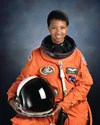 Photography of Mae C. Jemison posing in her orange NASA spacesuit