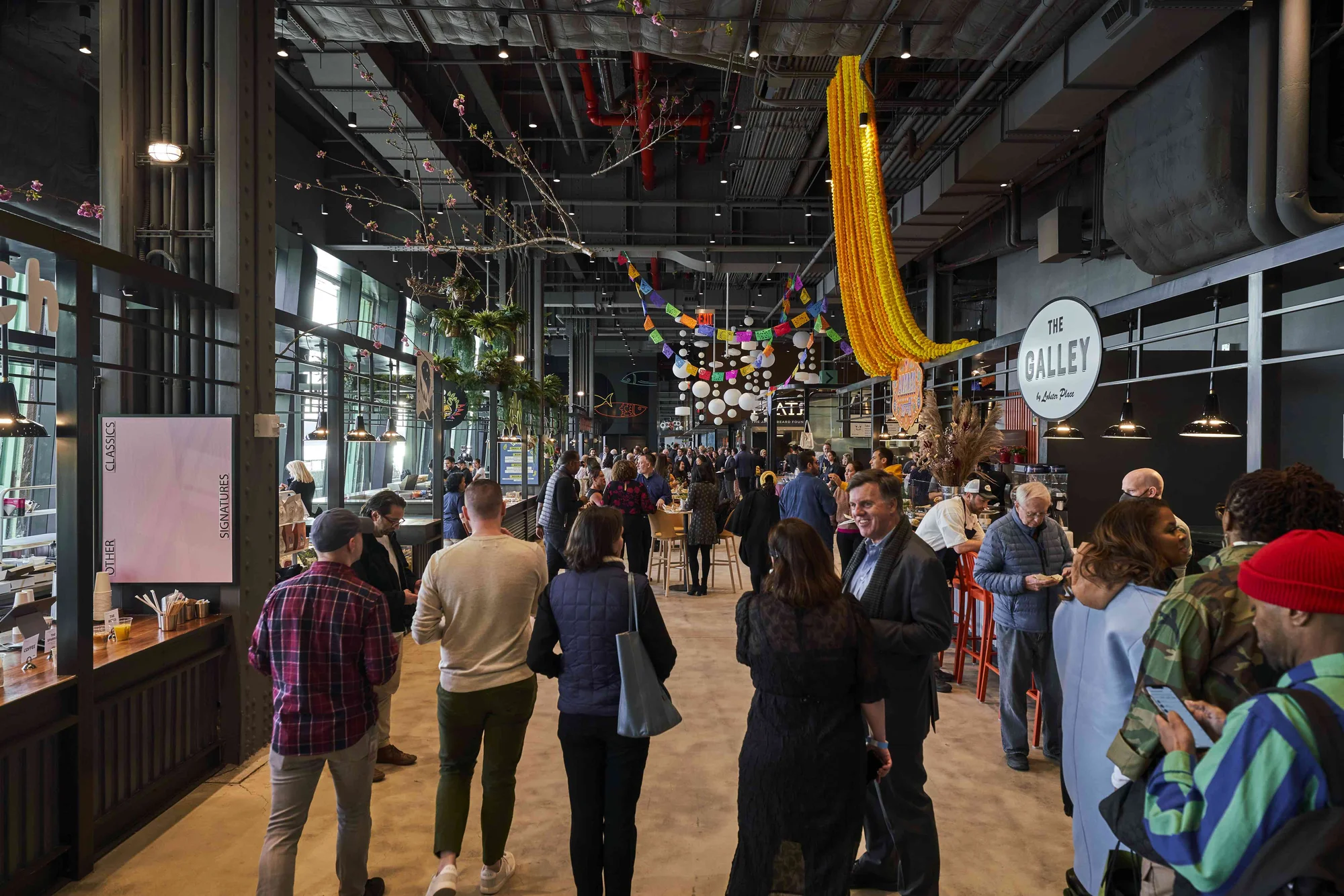 A indoor food hall is filled with people.