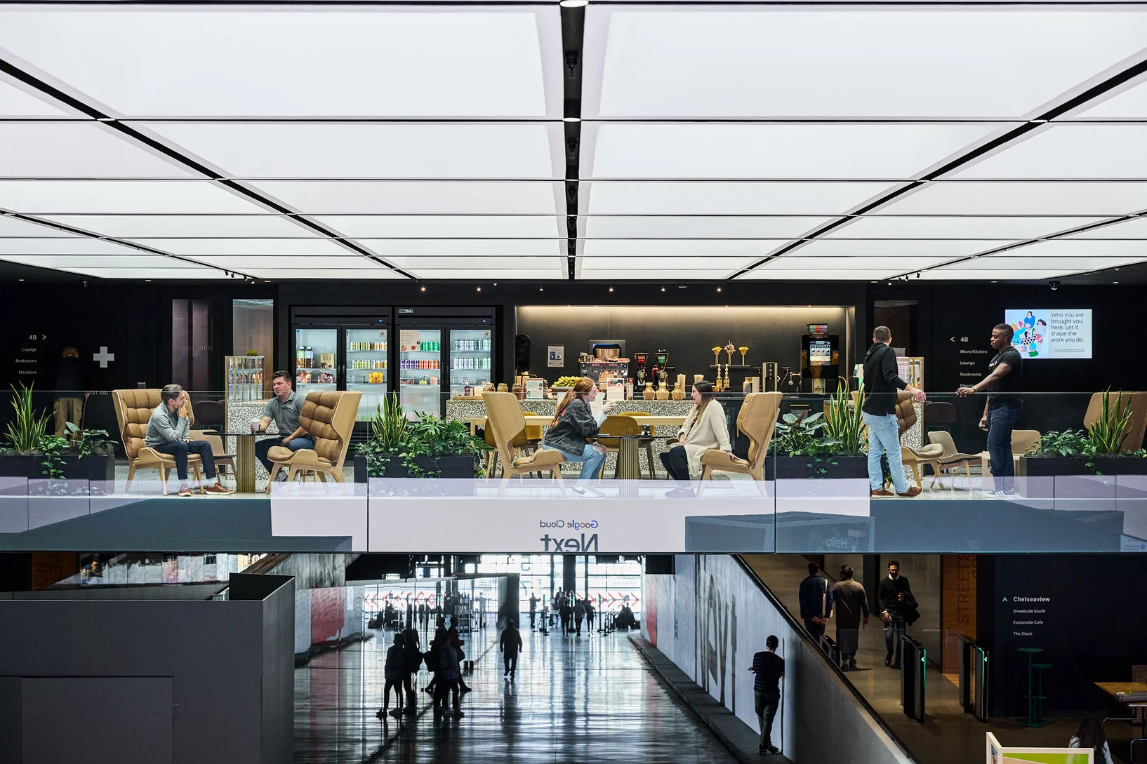 The interior of the building shows two floors filled with people sitting, walking and socializing.