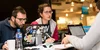 Three students at a table using laptops during the competition.