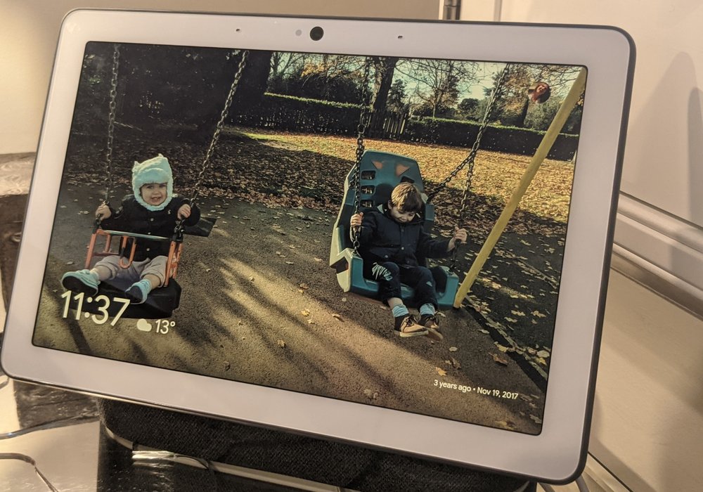 photo of a Next Hub Max displaying a photo of two children on swings