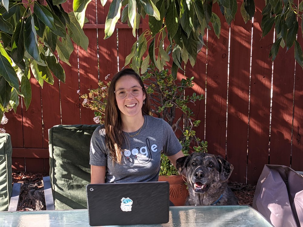 Emily sitting outside with her dog.