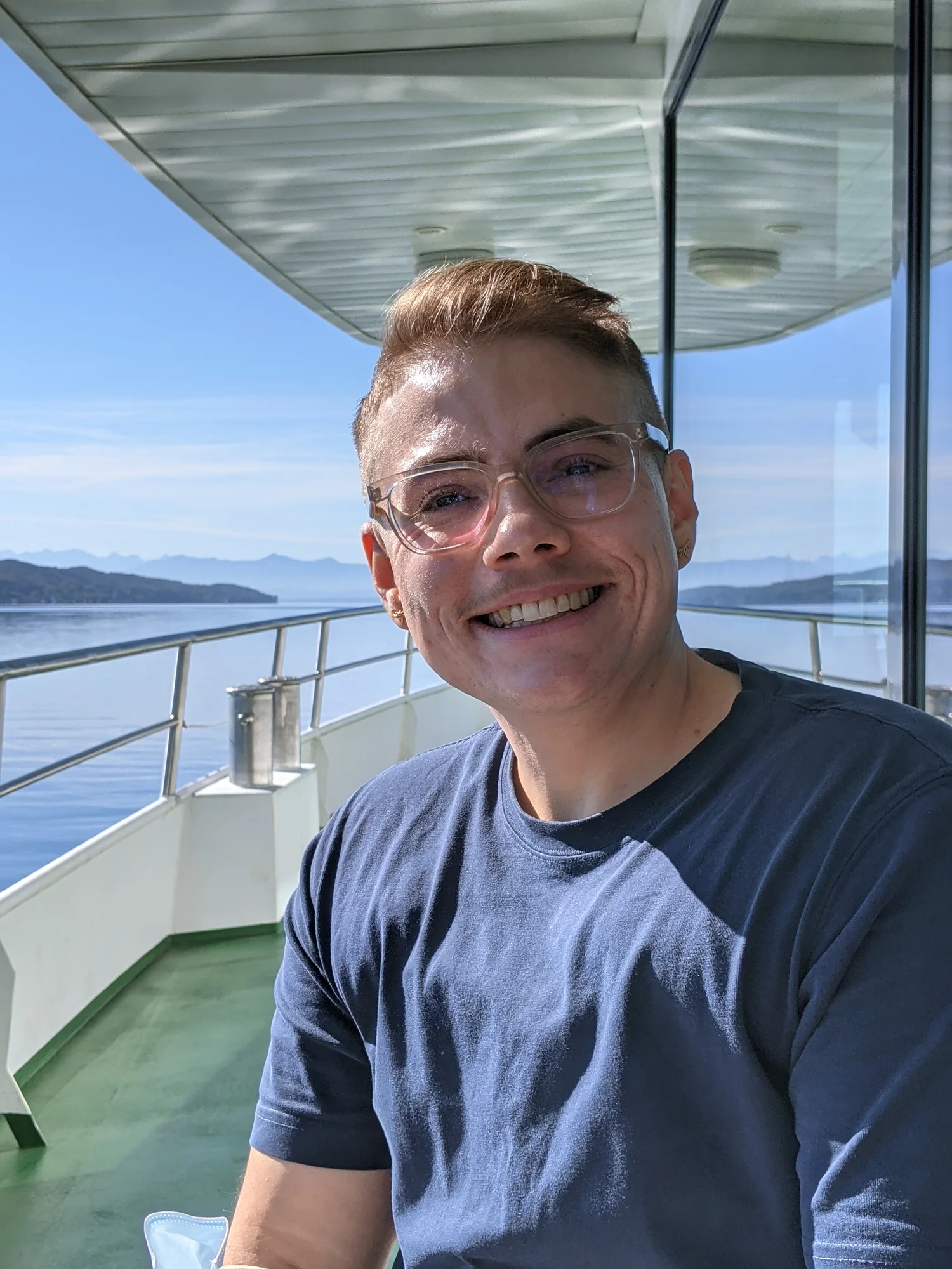 Porträtfoto von Adrian Hausner auf einem kleinen Schiff auf dem Starnberger See
