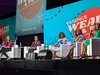 Five women sit in square white armchairs on a stage. The stage backdrop reads “#ESSENCEFEST.”