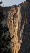Photograph of Yosemite’s Horsetail Falls zoomed in to see the rock glowing yellow.