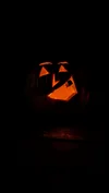 A photo in the dark showing a jack-o-lantern face lit up.