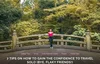 A woman in a bright pink tank top and jeans leans back against the stone railing of a bridge set in a forest.