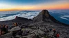 an image taken from the peak of Mount Kinabalu in Malaysia showing people hiking around and a sea of clouds