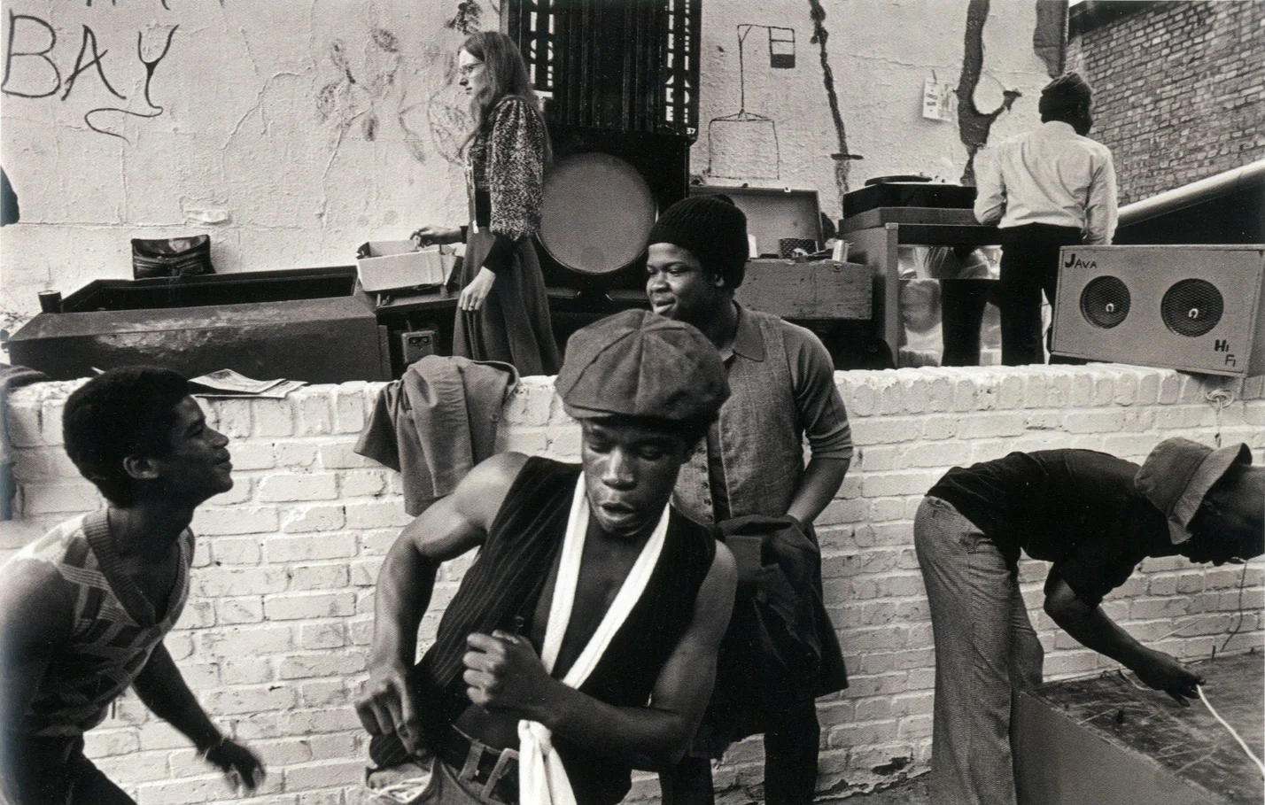 A black and white photograph of Notting Hill Carnival in 1975, taken by Chris Steele-Perkins.  The photograph depicts Black children dancing on the streets of Carnival