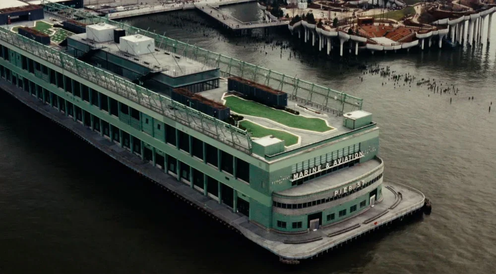 An aerial view of Pier 57 on the Hudson River with the Manhattan skyline in the background.