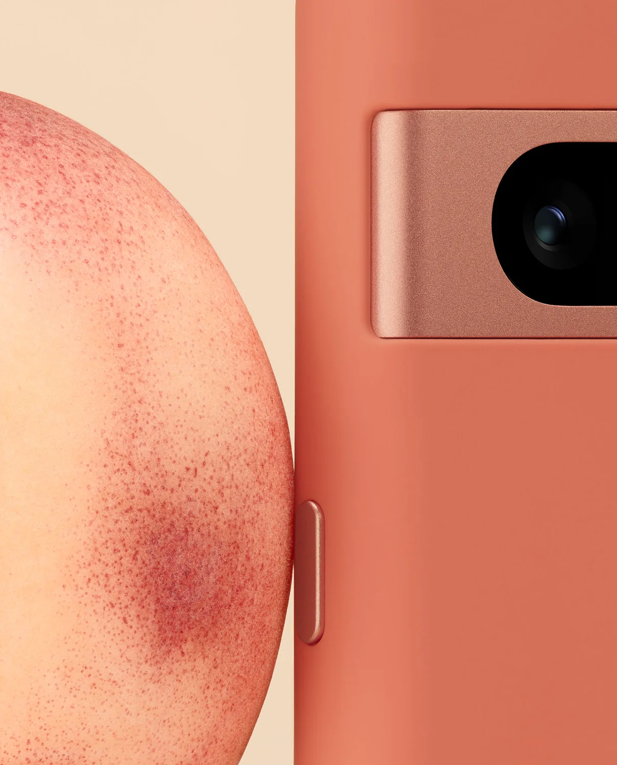 A photo showing the side of a Pixel 7a in Coral next to the skin of a peach, showing their corresponding colors.