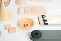 Photograph of various yellow to peach to pink items as well as a gold hoop earring and a Sorta Sunny Pixel 6 Pro on a white table.