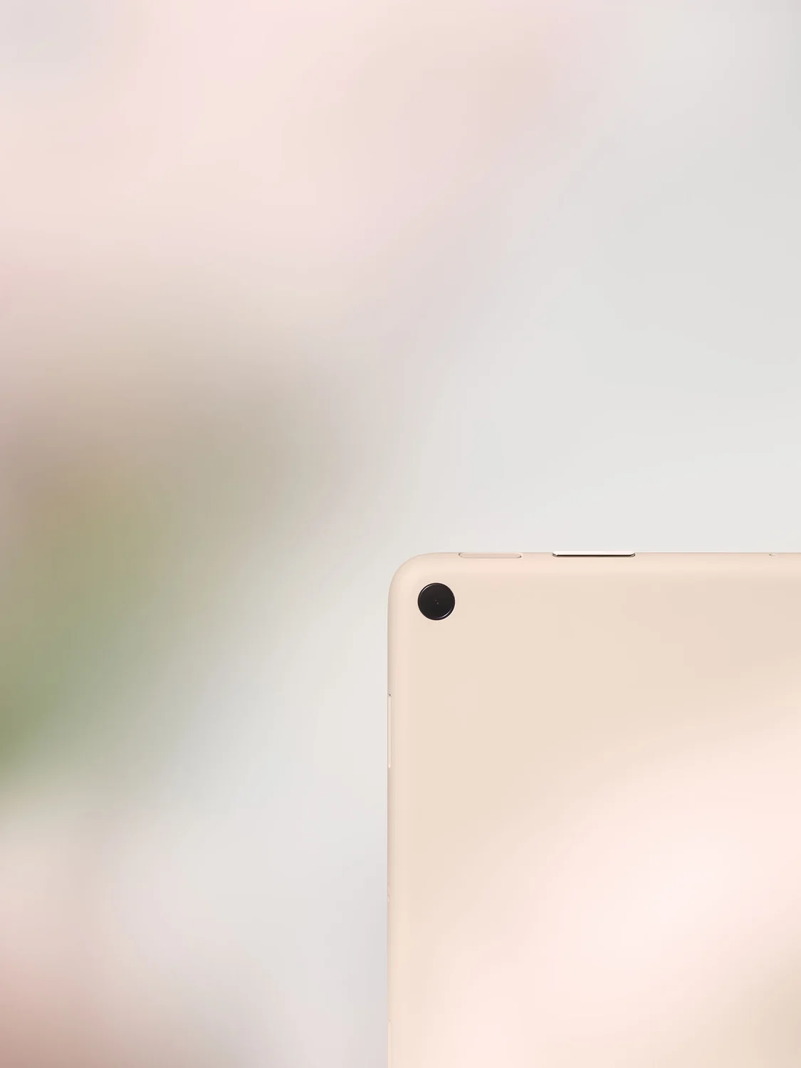 A close-up of the corner of a Pixel Tablet in Rose.