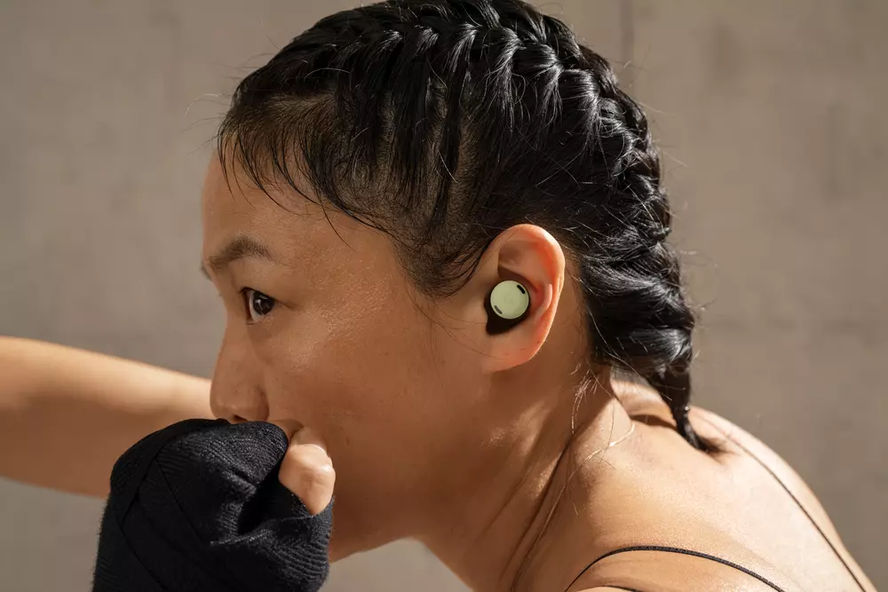 A close up shot of a person in athletic gear wearing Pixel Buds Pro in their ear.