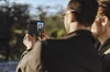 Two people use the Rear Camera on the Pixel Fold to take a selfie. We see the back and sides of their heads as they smile at the camera