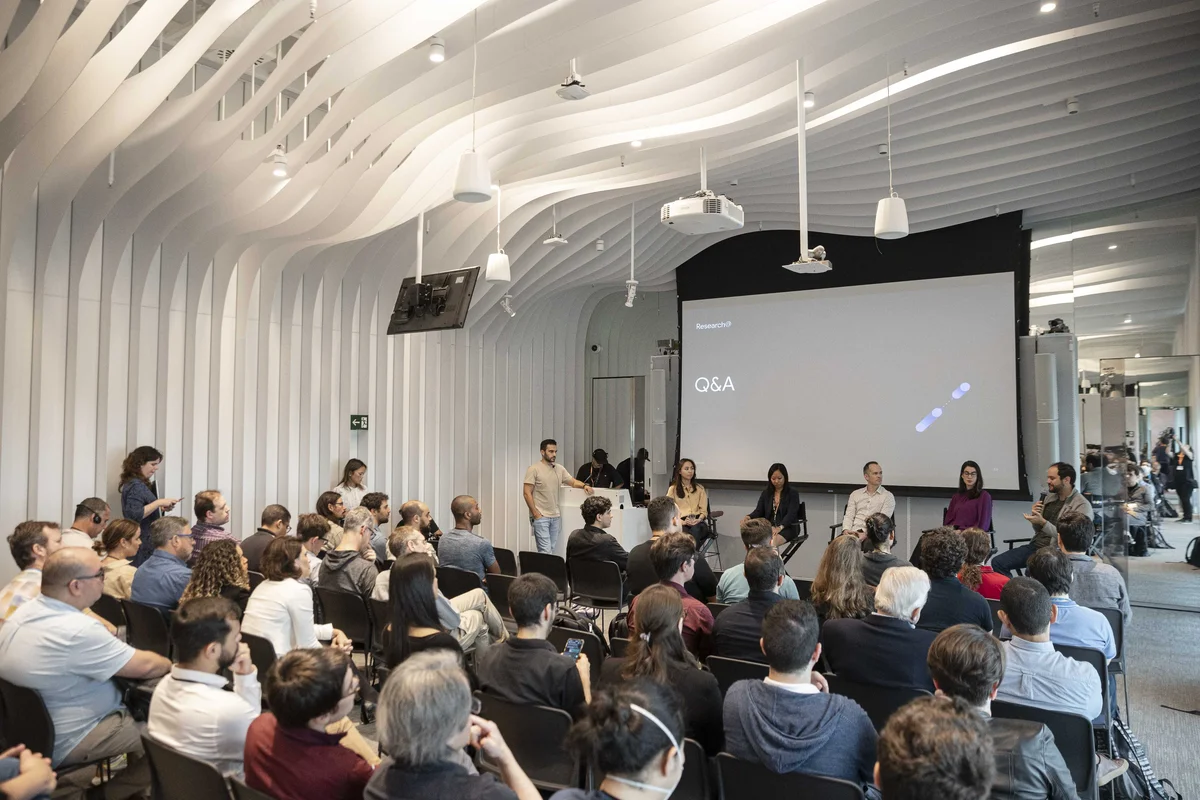 Pesquisadores  do Google conversam com uma audiência de pesquisadores de universidade e parceiros em uma plateia no escritório do Google