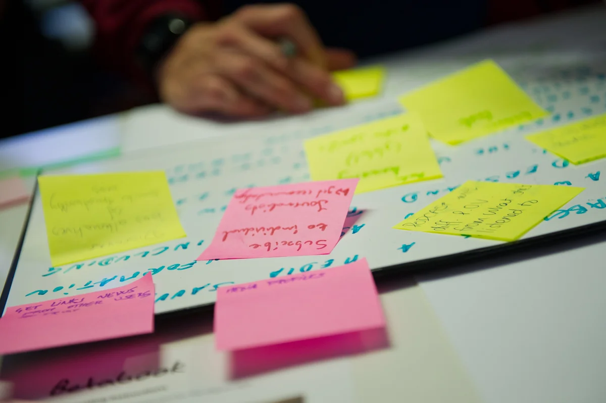 A journalist writes down business ideas on sticky notes