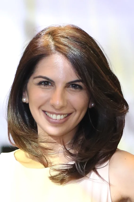 A woman with brown, shoulder-length hair smiles at the camera.