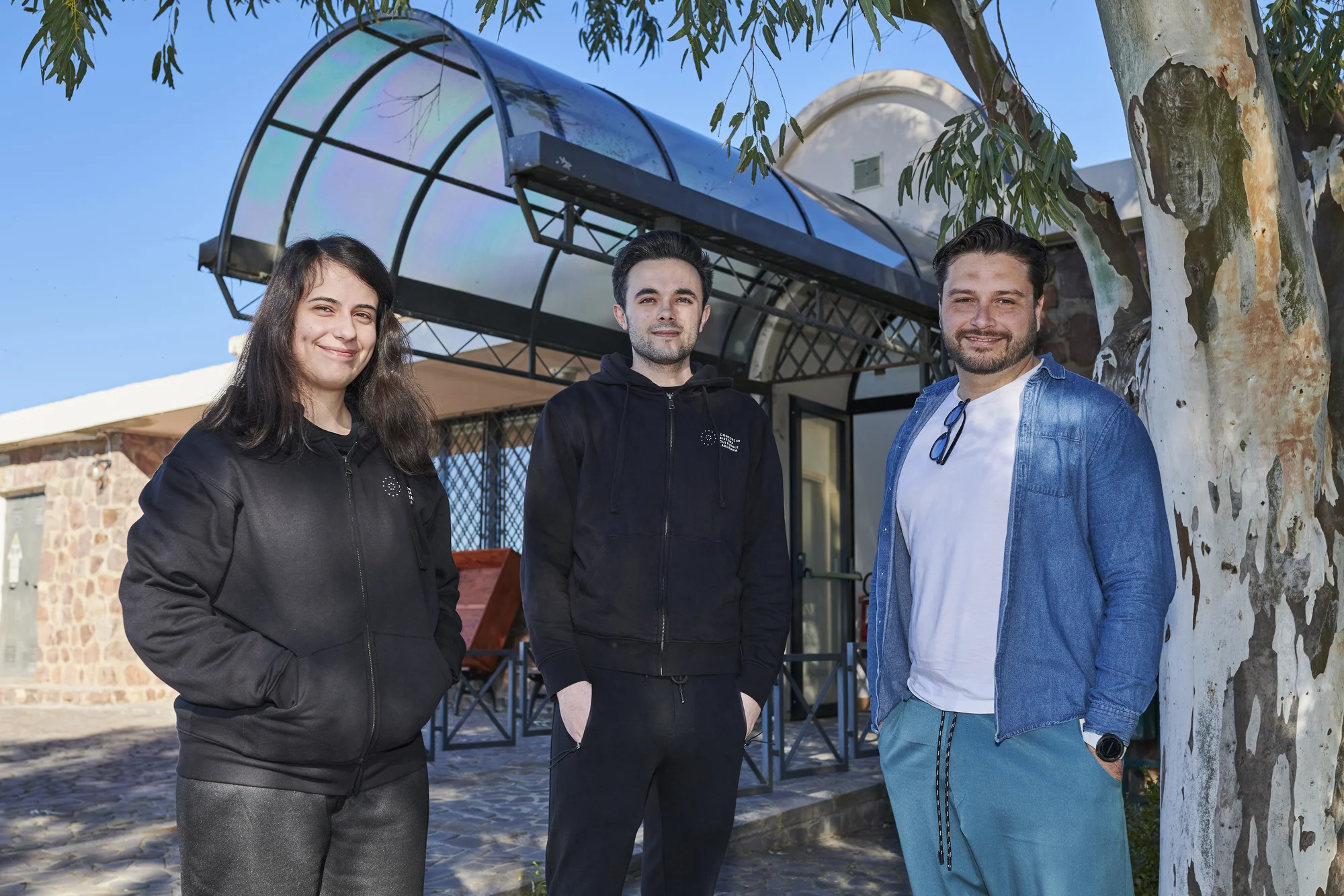 Gruppo di persone in posa davanti a un albero