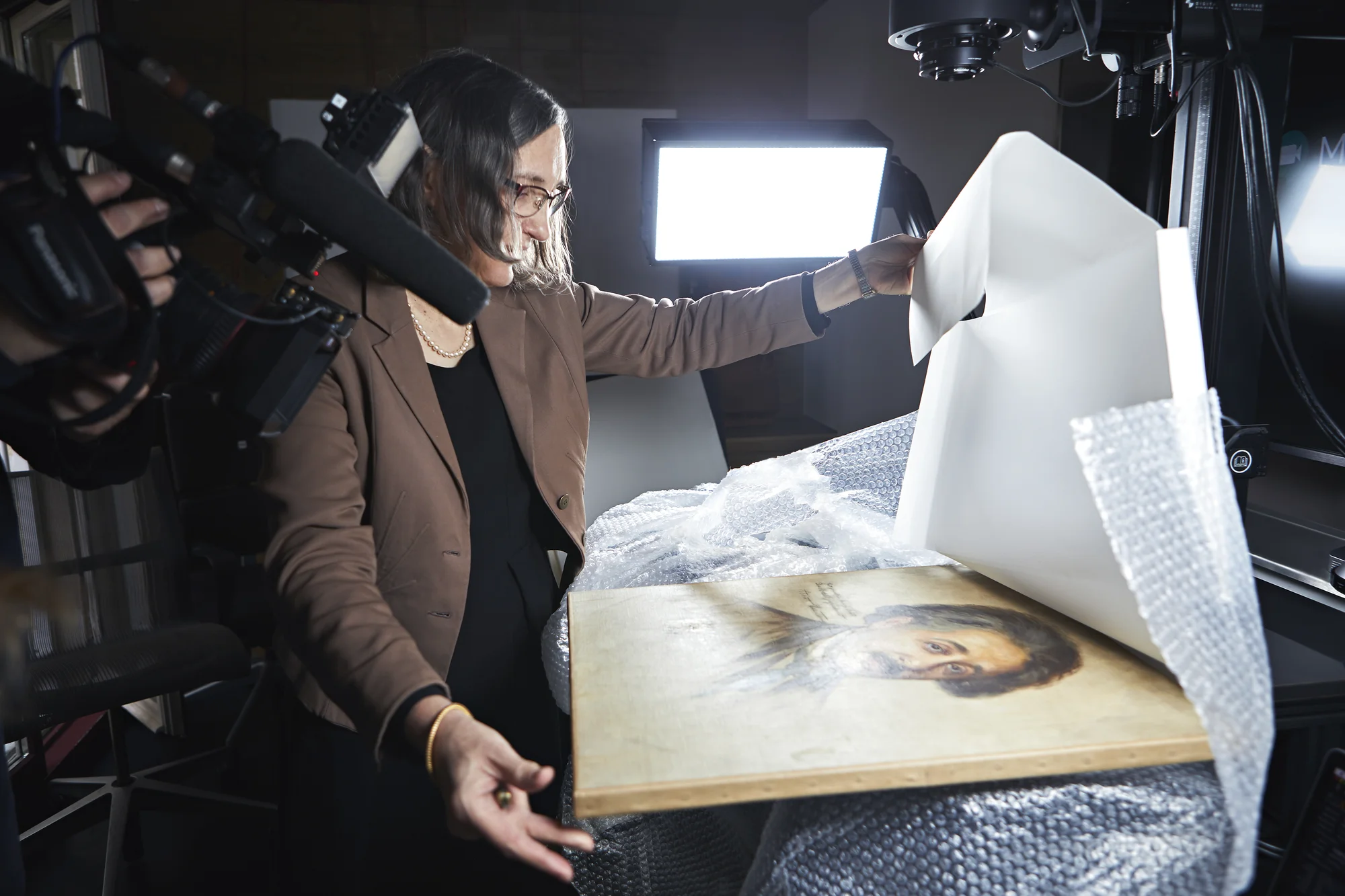 Image of a person unwrapping an artwork