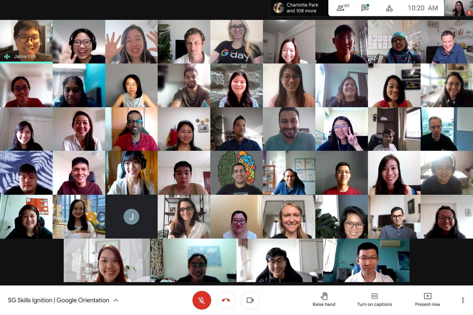 A video conference call of 50 people smiling or waving to the camera.