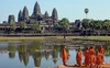 An Image of the Angkor Wat with a groups of monks wearing orange tunics