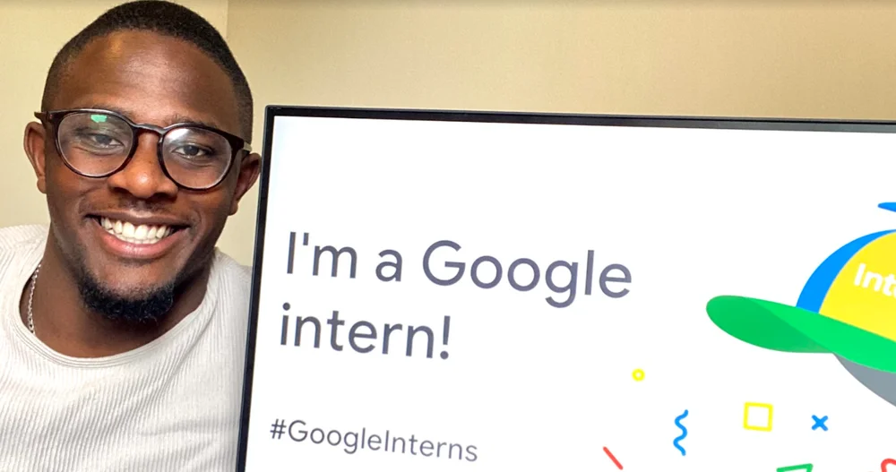 A picture of James Frater smiling next to a computer screen saying 'I'm a Google intern!'
