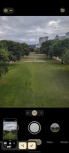 A screenshot of the camera app on a Pixel 6a. The screen shows that the camera is photographing a park landscape; there is a straightening tool in the center of the photo indicating the phone is level.