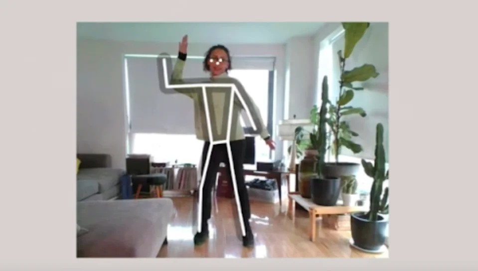 Image of a woman striking a dance pose in a living room