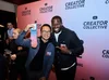 Two YouTube creators smiling and holding up a pair of branded socks at the Creator Collective event