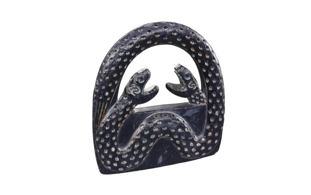 A chrysotile dark gray arch of snakes that loop into one. The snakes have open mouths and are engraved with dots throughout.