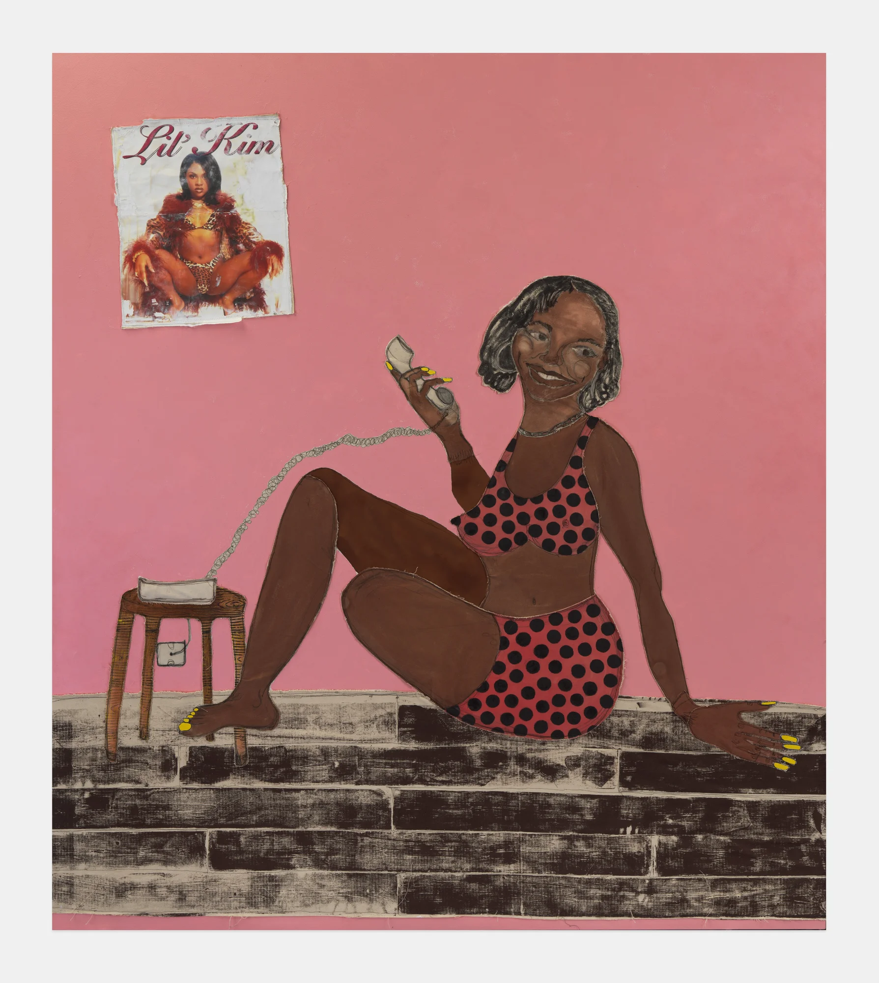 A painting with a pink background serving as a wall. On this pink wall, there is a white poster of Lil Kim, squatting, wearing a fur coat and a short black bob. Her name appears over her in cursive red letters. Sitting by the wall, on the floor, is a woman with a short, black bob, wearing a pink two-piece shorts and cropped cami set with black polka dots. She has long, yellow nails and a smile on her face as she holds an off-white landline phone that sits on a stool next to her.