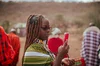 Image of a young woman holding a red mobile phone