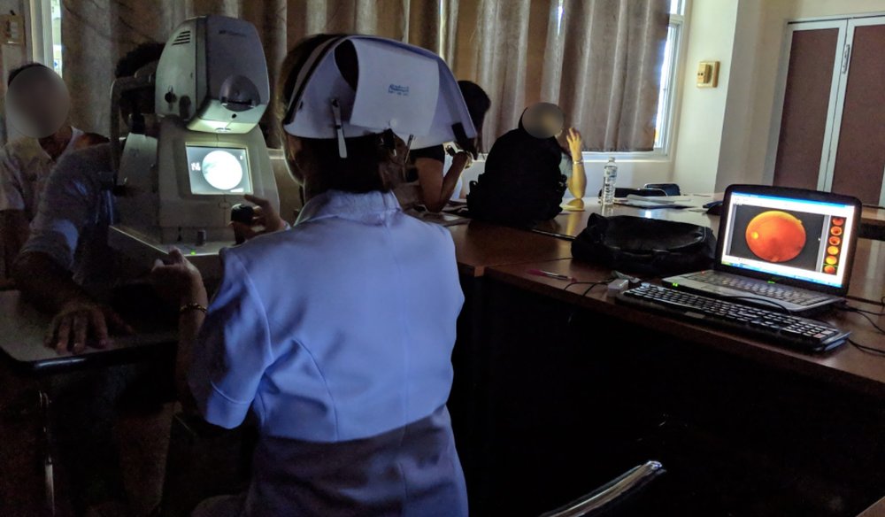 A nurse operates the fundus camera, taking images of a patient's retina.