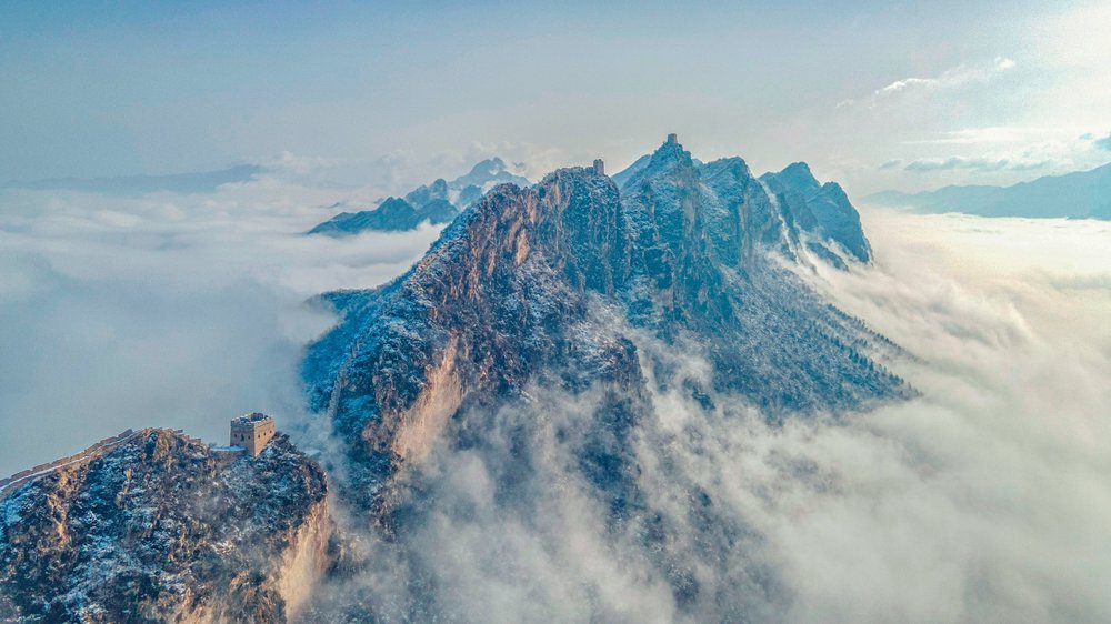 A section of the Great Wall known as the 'heavenly ladder' with an extremely narrow section of the wall leading up a mountain ridge, shrouded in misty cloud.