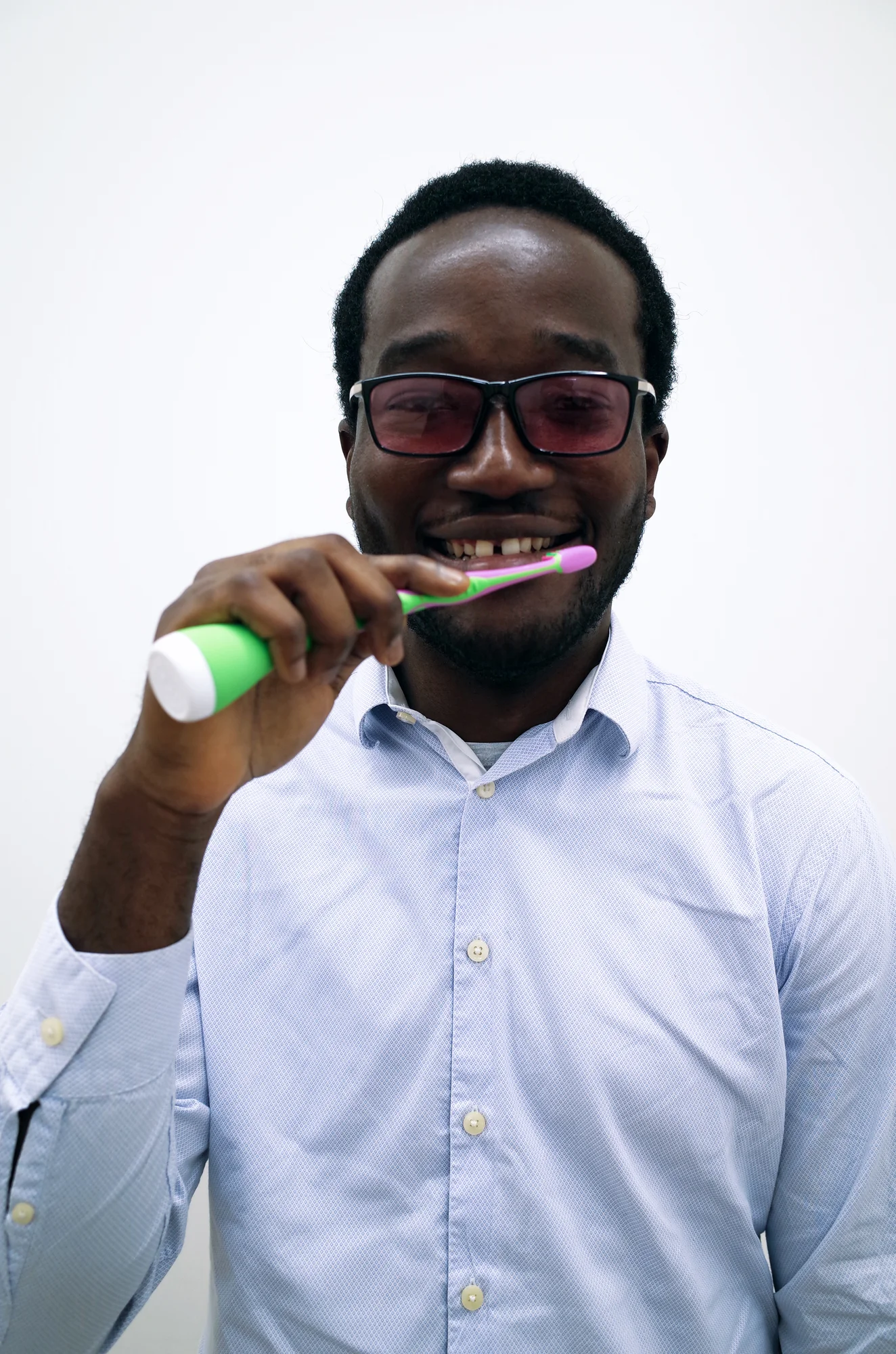 Tolulope Ogunsina looks into the camera, using a Playbrush toothbrush, smiling.