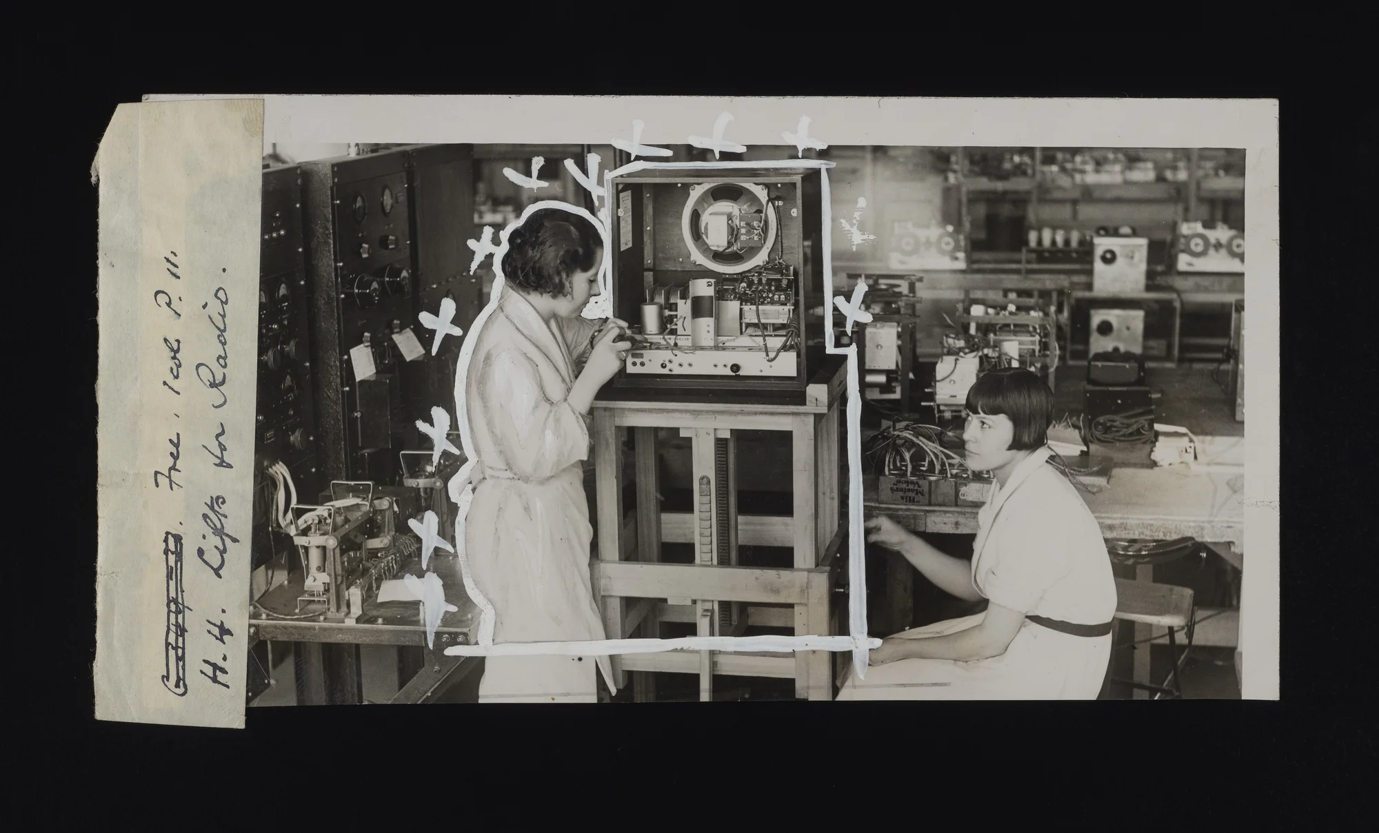 A black and white photograph of two women building radios