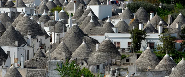 An aerial view of white houses with conical grey roofs