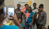 Students posing in a photo booth with hand held signs and props.