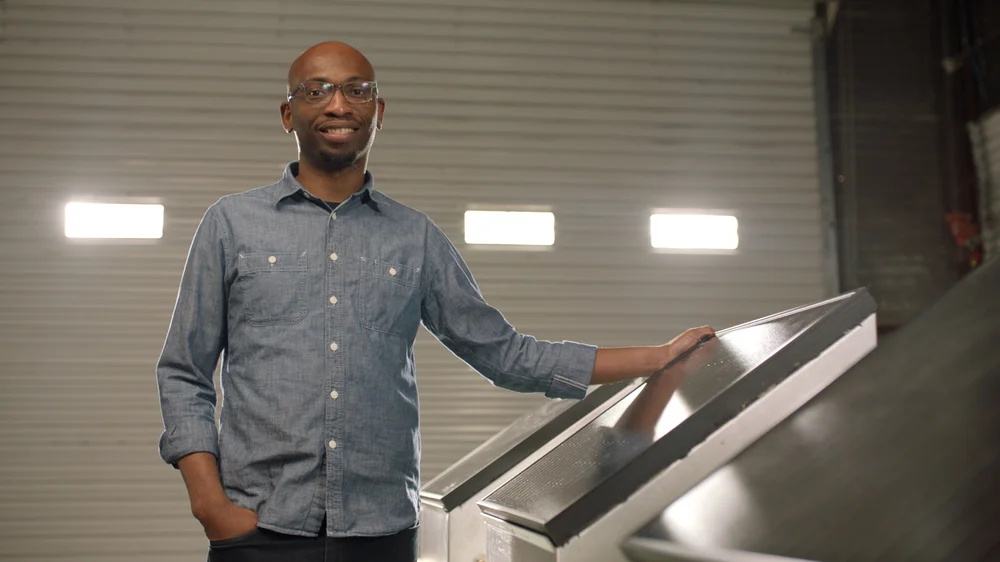 Seyi Fabode, founder of Varuna, standing near his water sensors